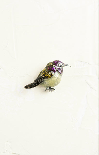 Decorative bird figurine with purple accents on a white background