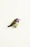 Decorative bird figurine with purple accents on a white background