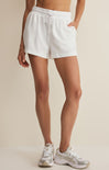 Person wearing white shorts on a beige background