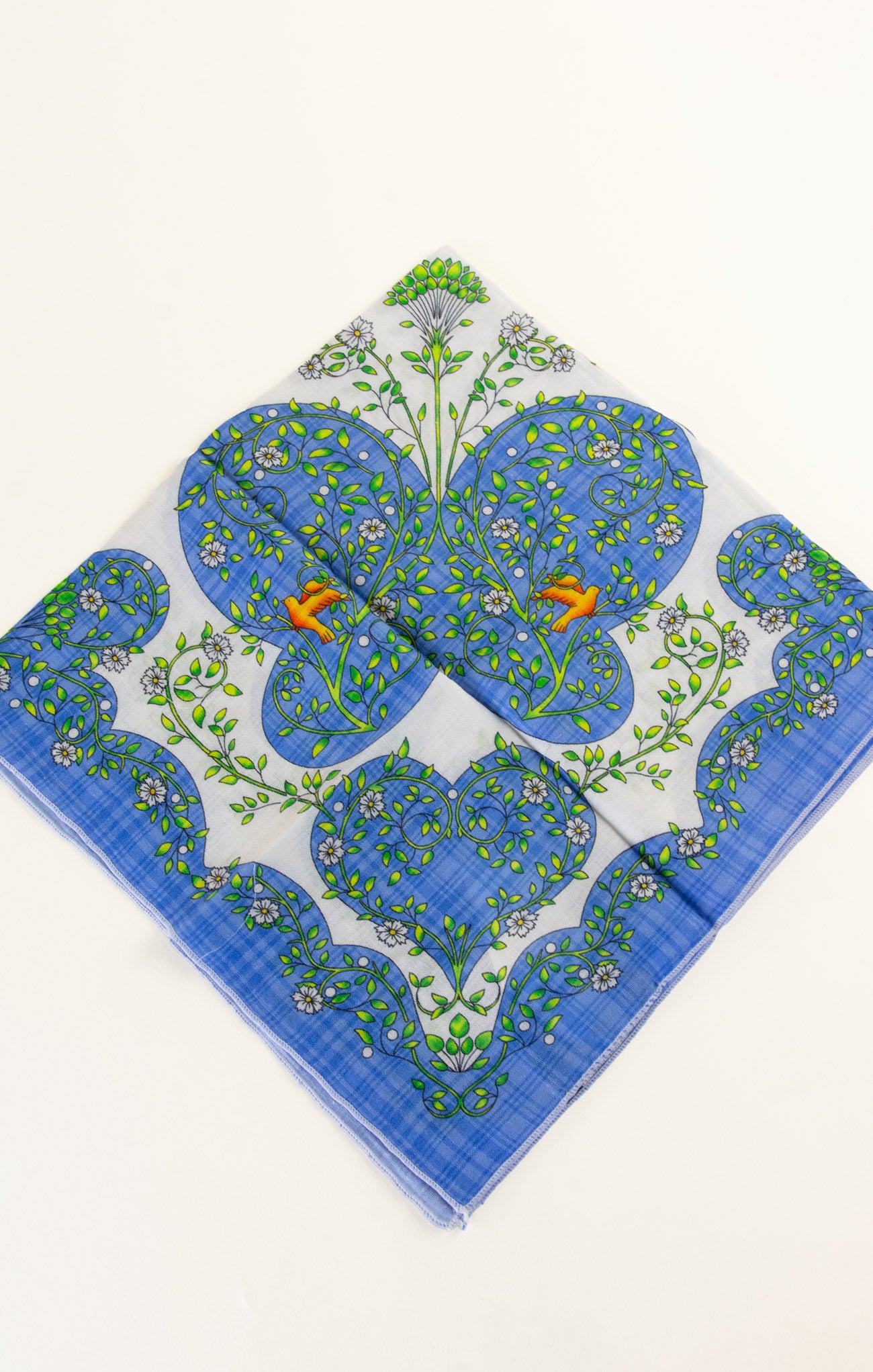 Blue floral patterned fabric square on a white background