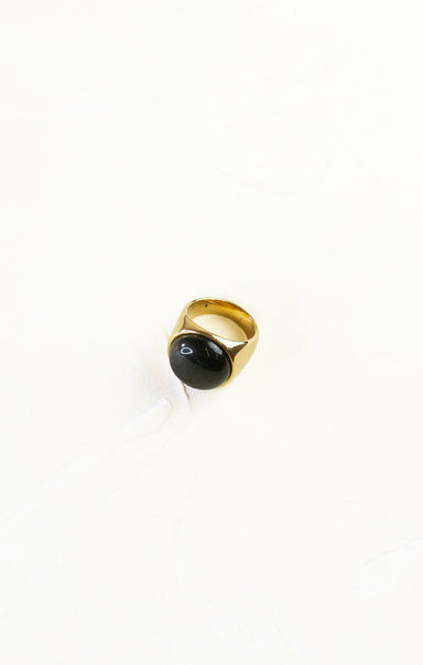 Gold ring with a black gemstone on a white background