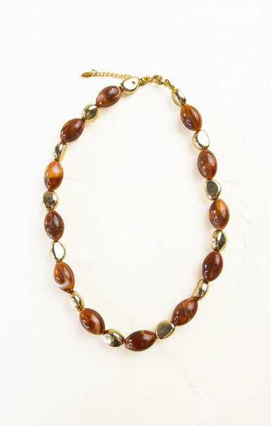 Necklace with brown beads and gold accents on a white background