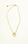 Gold necklace with a heart-shaped pendant on a white background