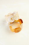 Set of three amber-colored bracelets on a white background
