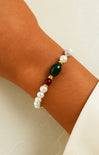 Bracelet with pearls and colored beads on a wrist against a neutral background