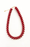 Red beaded necklace on a white background
