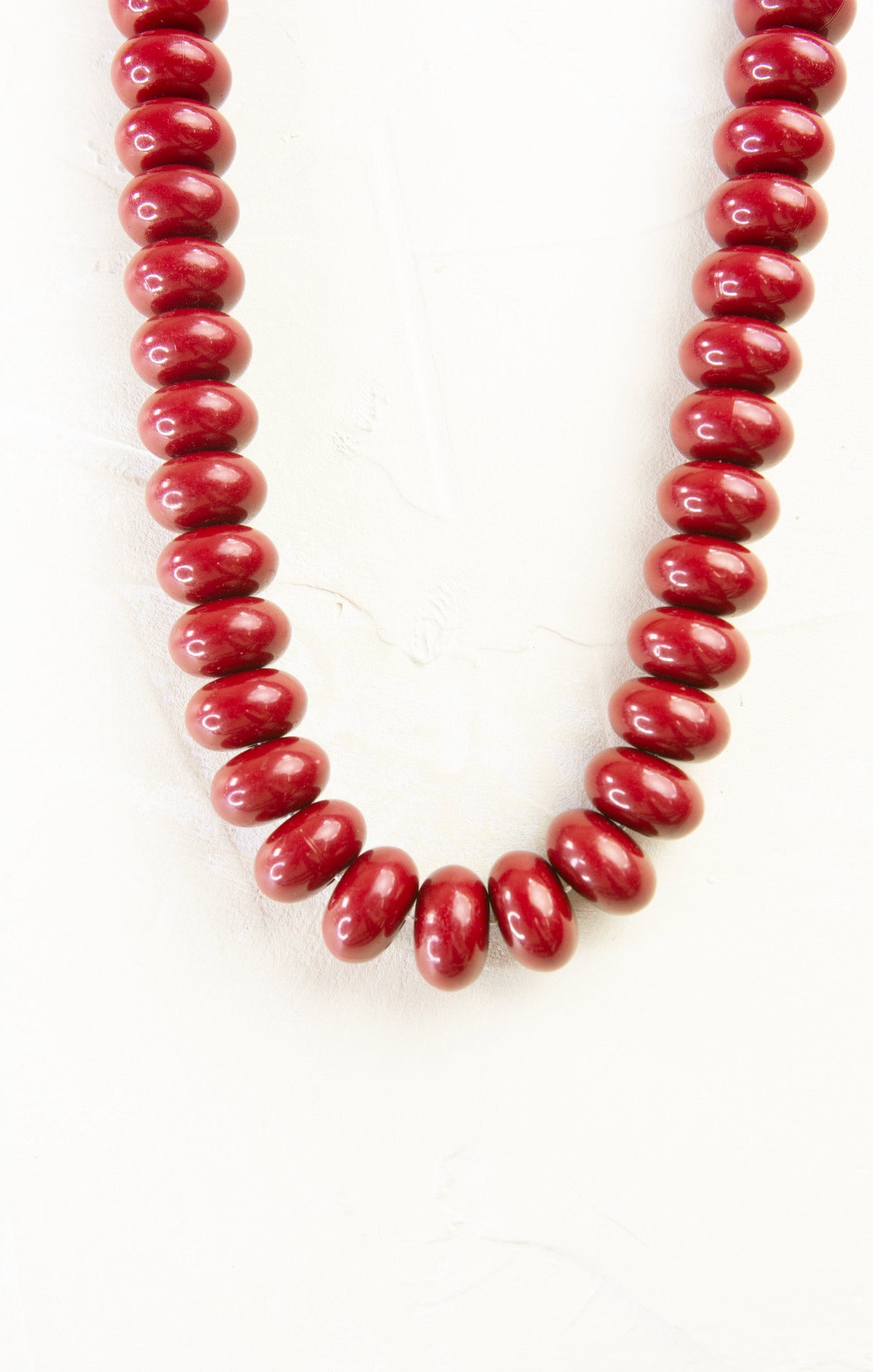 Red beaded necklace on a white background