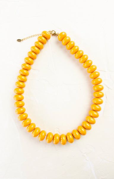 Yellow beaded necklace on a white background