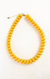 Yellow beaded necklace on a white background