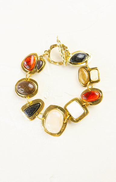 Gold bracelet with colorful stones on a white background