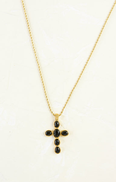 Gold necklace with a black cross pendant on a white background