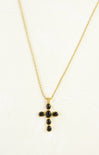 Gold necklace with a black cross pendant on a white background