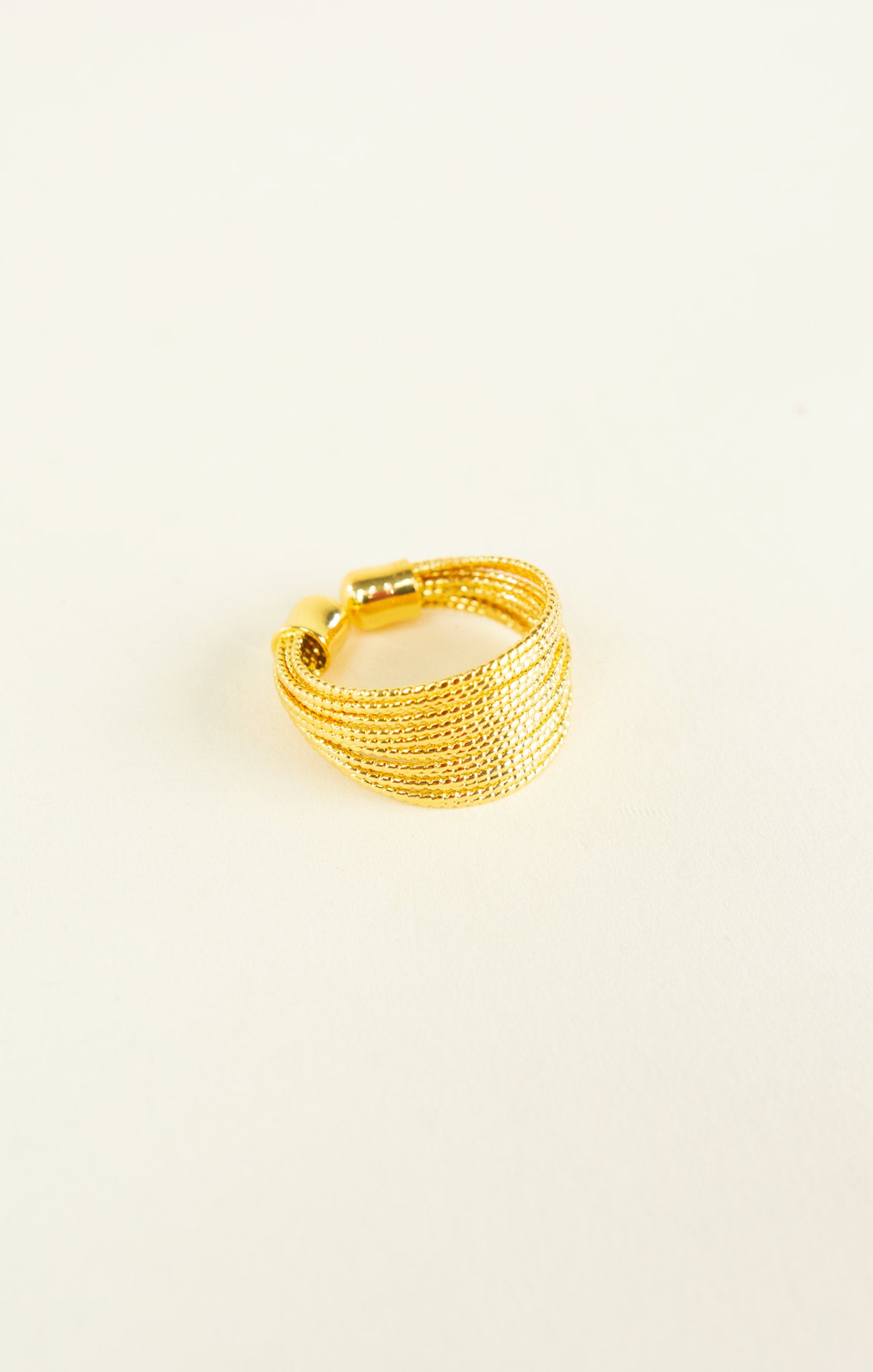 Gold ring on a light beige background