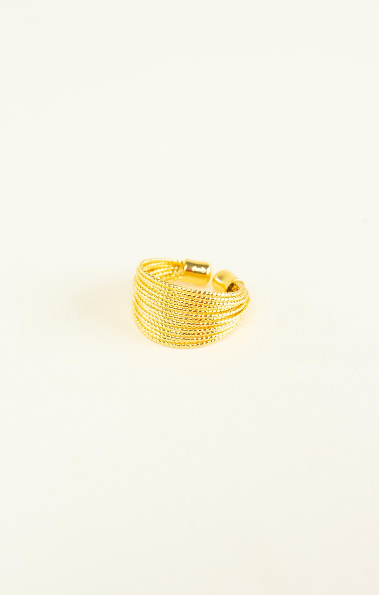 Gold ring with a textured design on a white background
