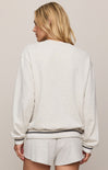 Person wearing a light gray sweatshirt and shorts set on a beige background