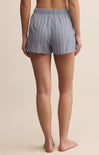 Person wearing blue striped shorts on a beige background