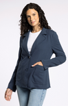 Woman wearing a navy blazer over a white shirt and light blue jeans on a white background