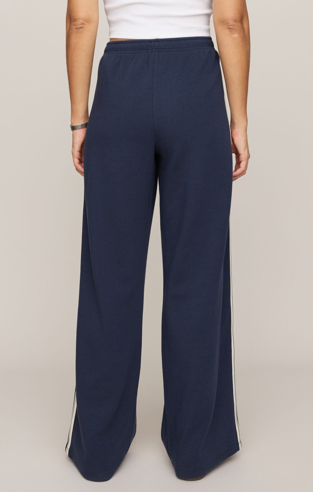 Navy wide-leg pants with a white top on a beige background