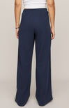 Navy wide-leg pants with a white top on a beige background