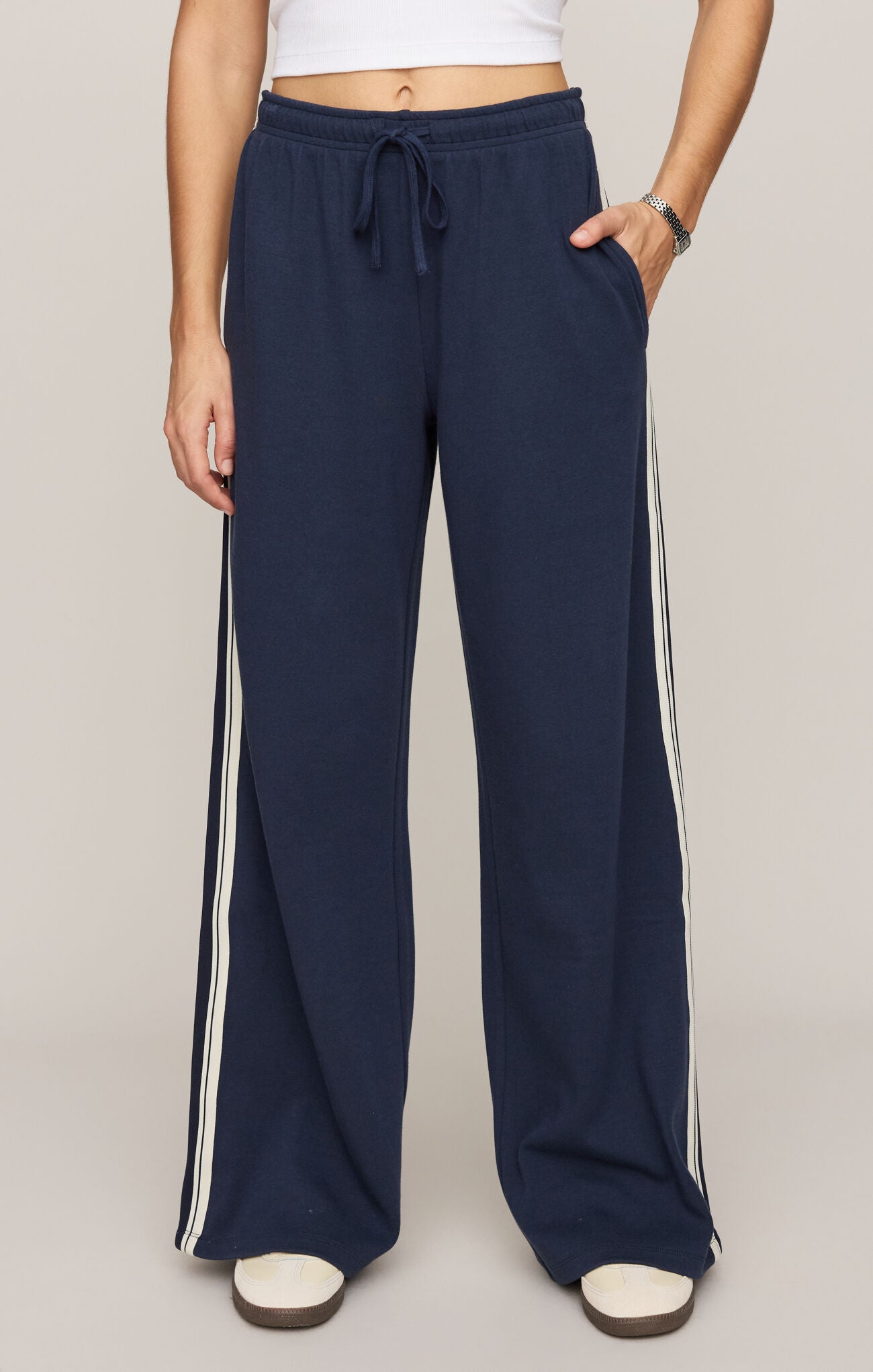 Navy wide-leg pants with white stripes on a plain background
