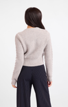 Person wearing a light gray sweater and dark pinstripe pants on a white background