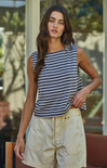 Woman wearing a striped tank top and beige shorts outdoors