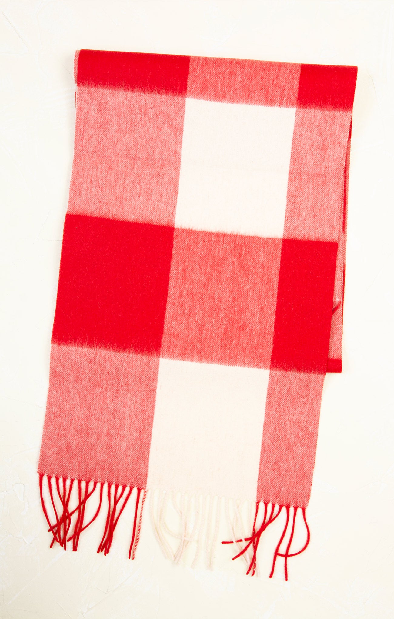 Red and white checkered scarf with fringes on a white background