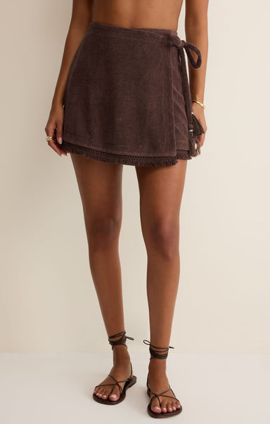 Brown towel skirt worn by a person on a plain background