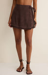 Brown towel skirt worn by a person on a plain background