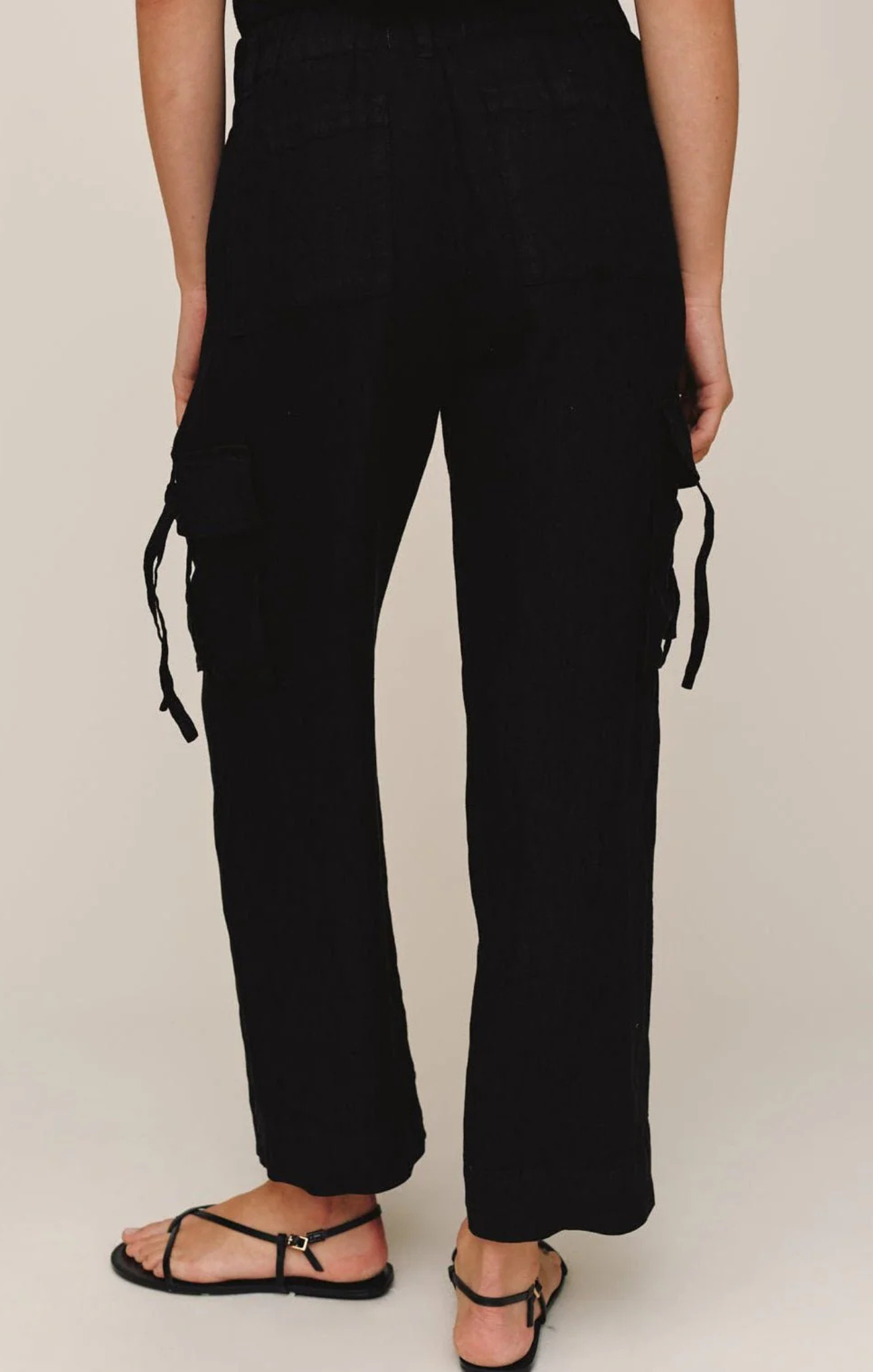 Black pants worn by a person on a plain background