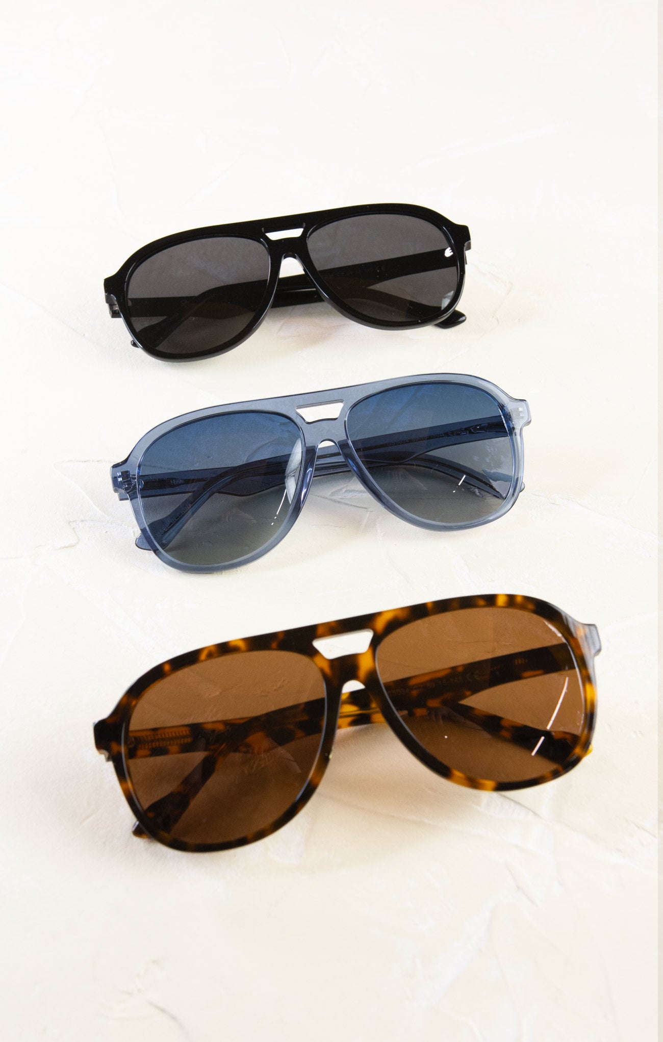 Three pairs of sunglasses with different designs on a white background
