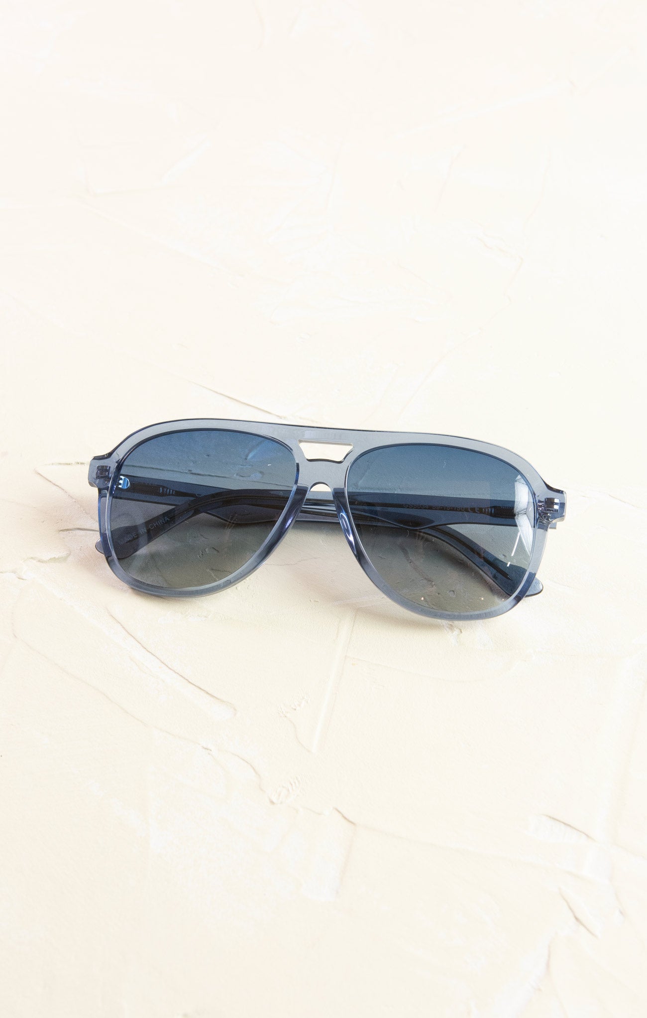 Blue sunglasses on a white surface