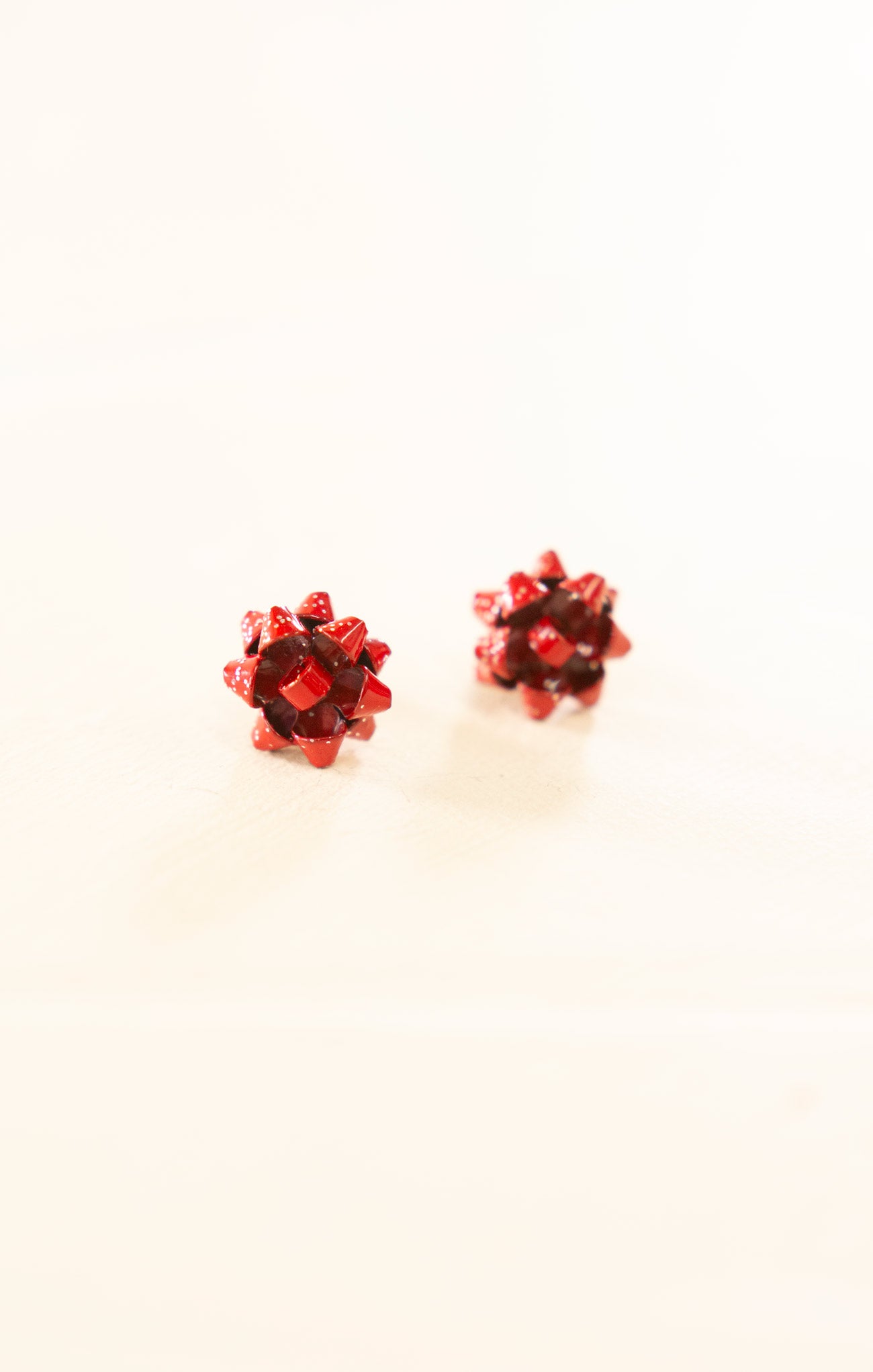 Pair of red gemstone stud earrings on a white background