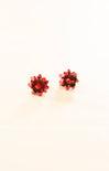 Pair of red gemstone stud earrings on a white background