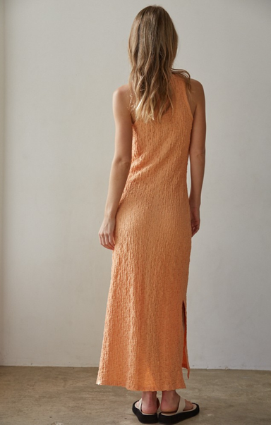 Woman wearing an orange dress against a plain background