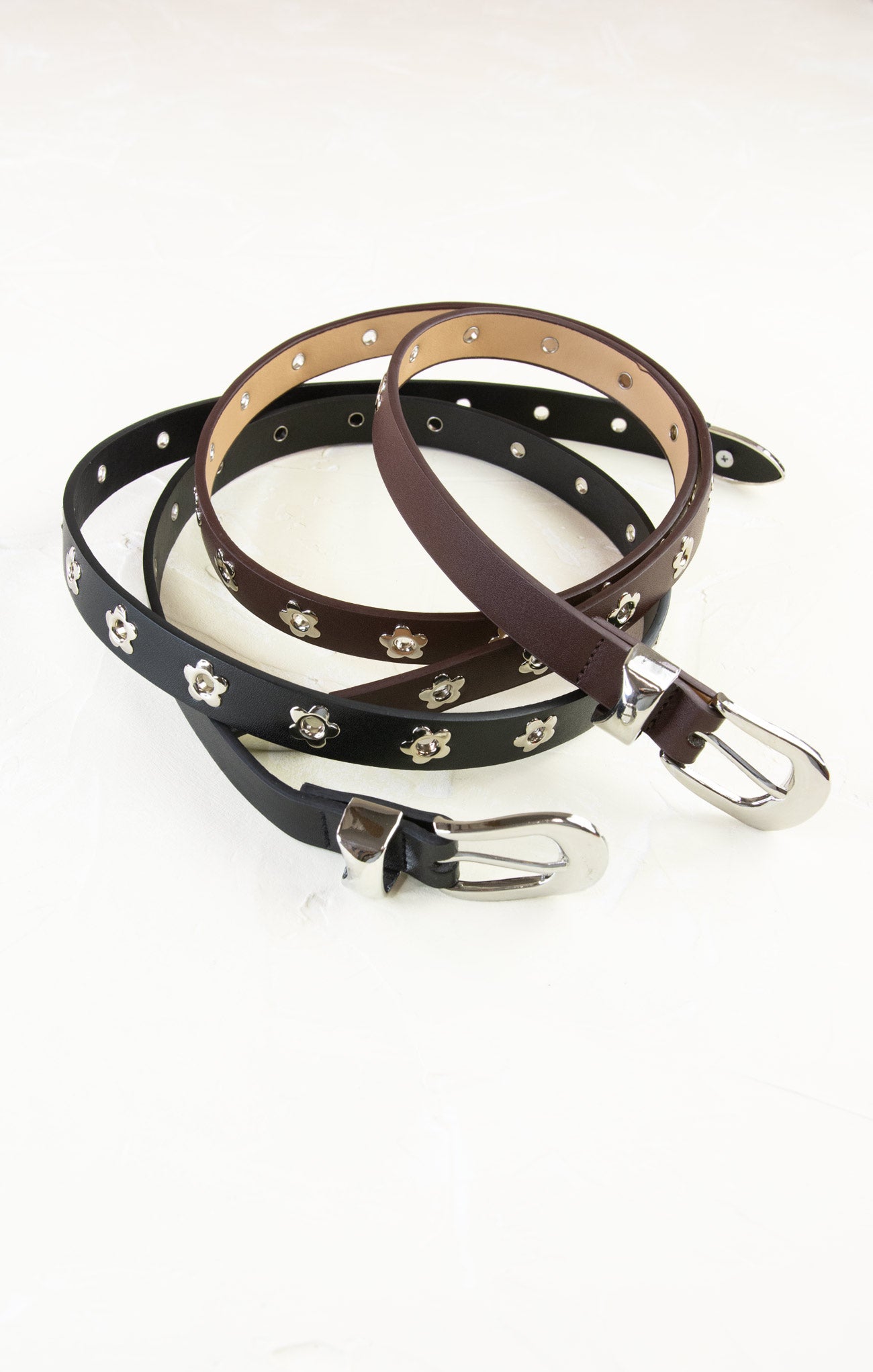 Two leather dog collars with studs on a white background