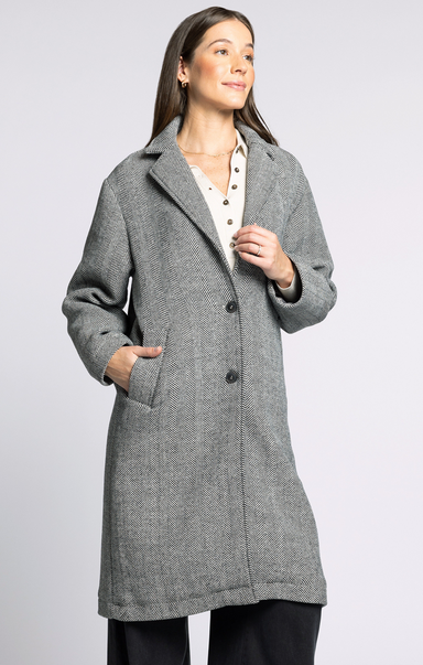 Woman wearing a gray coat on a light gray background