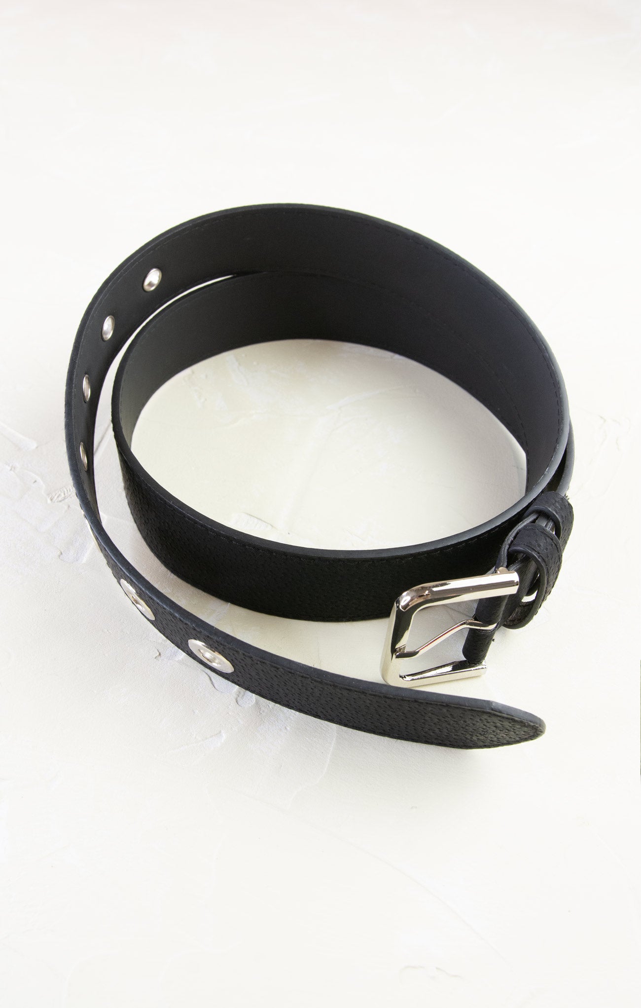 Black leather collar with metal buckle on a white background