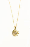 Gold necklace with a sun and moon pendant on a white background