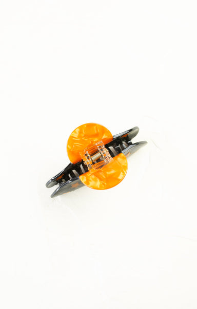 Butterfly-shaped hair clip with orange and clear design on a white background