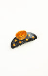 Decorative hair clip with sun and star designs on a white background