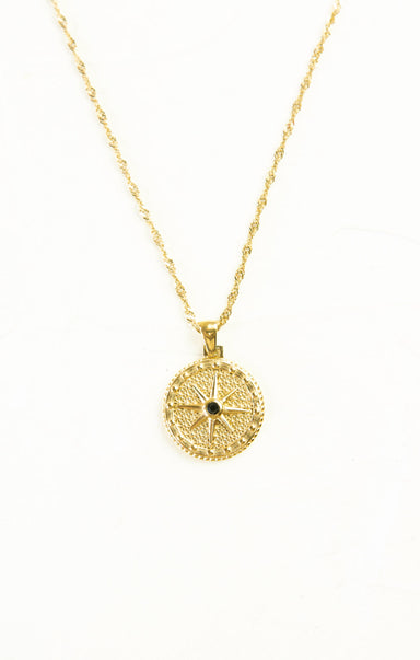Gold necklace with a circular pendant on a white background
