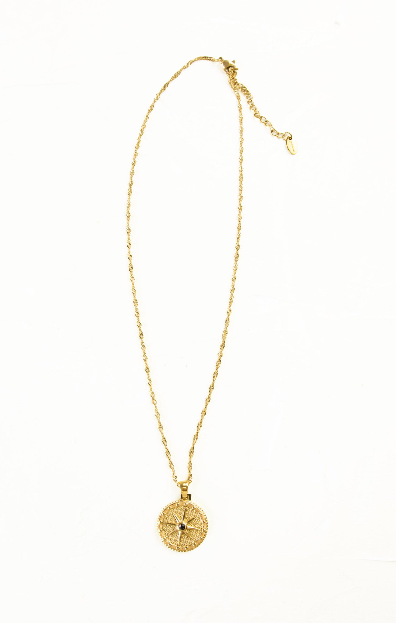 Gold necklace with a round pendant on a white background