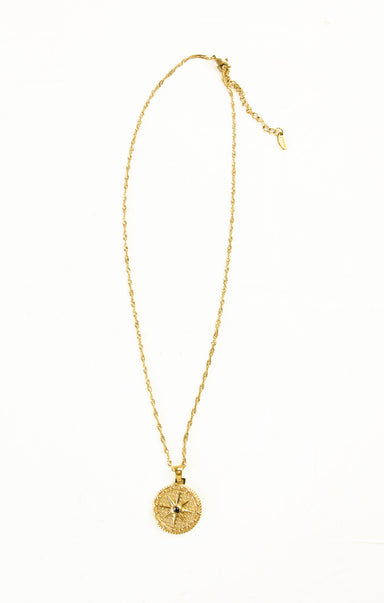 Gold necklace with a round pendant on a white background
