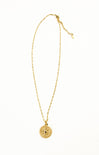 Gold necklace with a round pendant on a white background