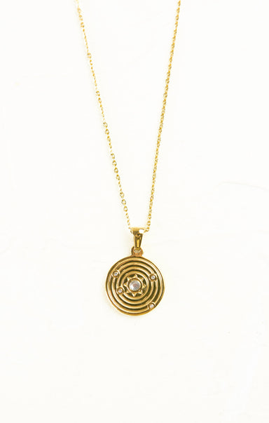 Gold necklace with a circular pendant on a white background