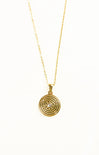 Gold necklace with a circular pendant on a white background