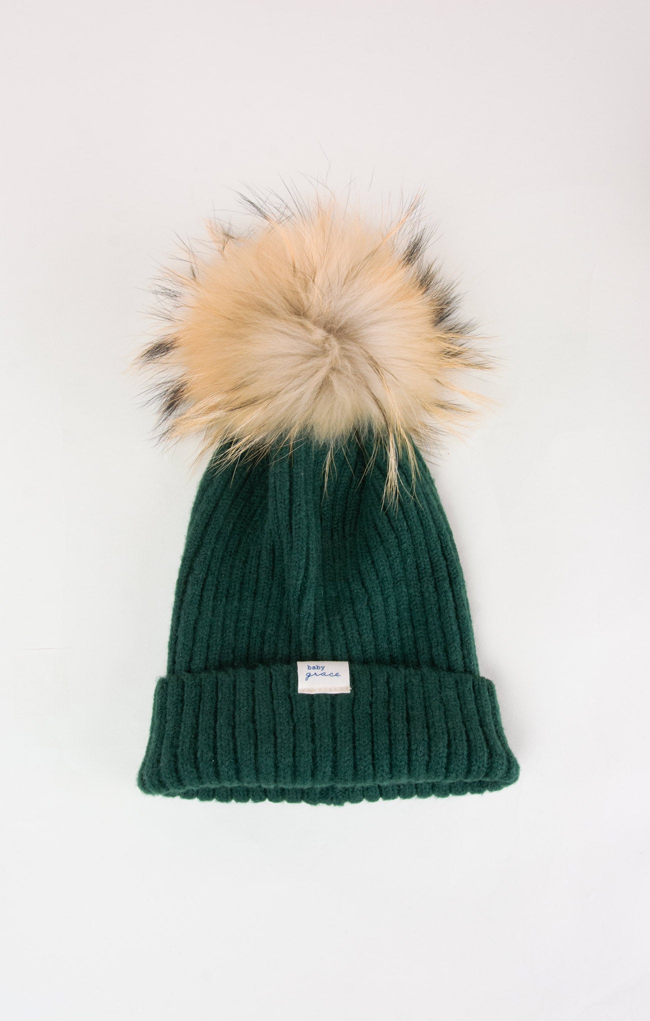 Green knit beanie with a faux fur pom-pom on a white background