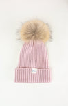 Pink knit beanie with a large fur pom-pom on a white background