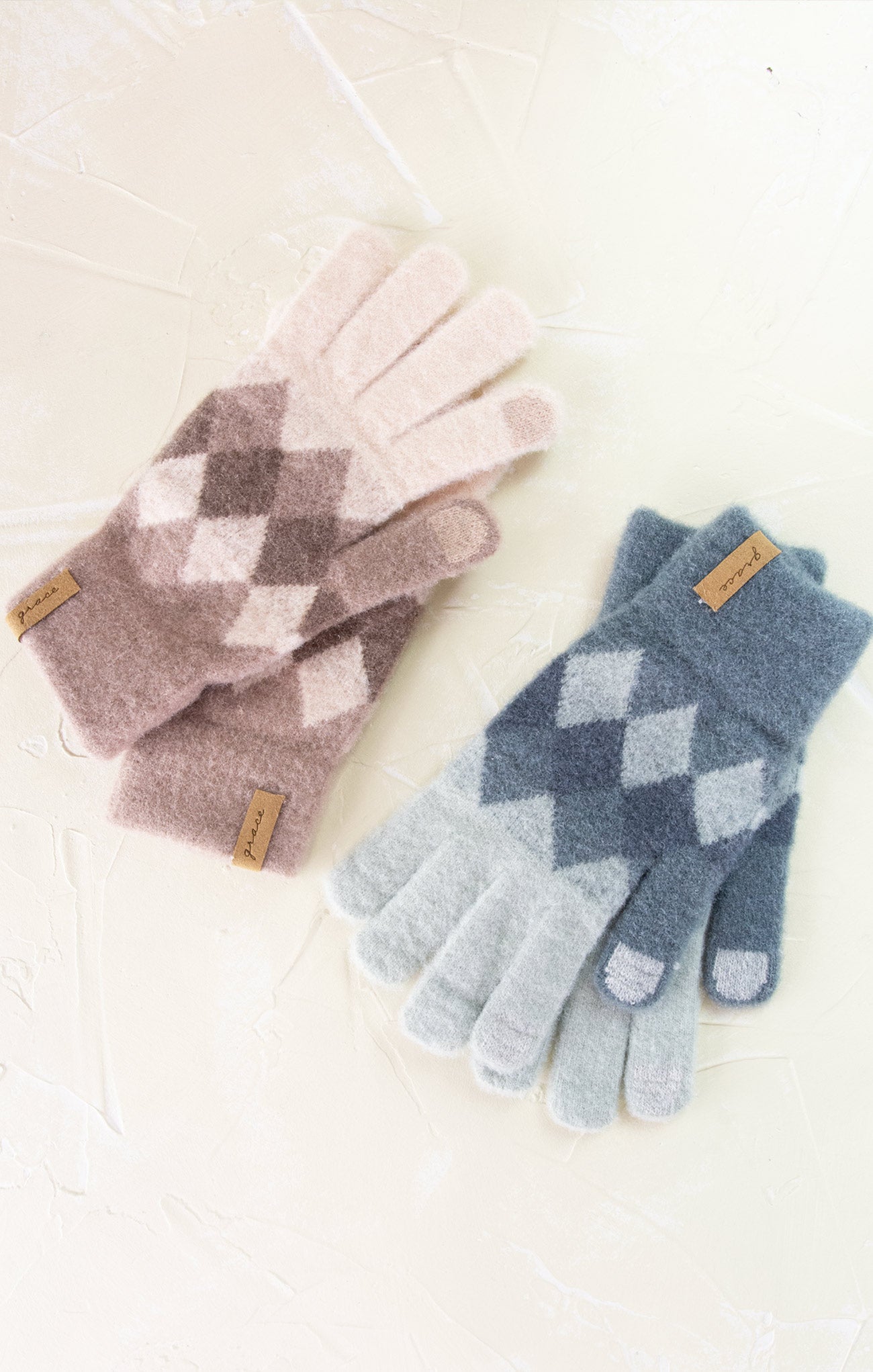 Pair of argyle patterned gloves in pink and blue on a white background